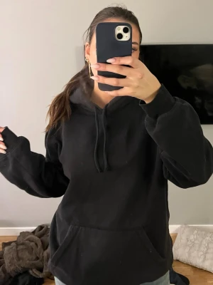 Svart hoodie  - svart hoodie med stor huva och ribbade muddar 