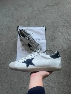 Golden Goose skor - Ett par sjukt snygga Golden Goose i en unik men sjukt snygg färg!🌟 mörkblå häl och mörkblå stjärna! Storlek 43. Dustbag fås med som syns i bilden! Kvitto och äkthetsbevis finns!😊 Skick 9/10, grymt skick!