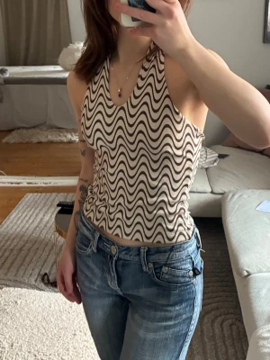 Halternecktopp - Säljer min vita halterneck topp med coolt mönster i storlek xs.