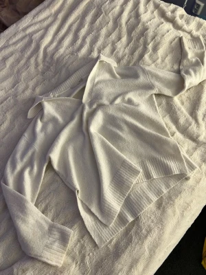 Vit stickad tröja från 157 - Säljer en stilren vit stickad tröja från 157 i storlek XS. Tröjan har en bred ribbstickad mudd vid ärmslut och nederkant samt en snygg krage. Perfekt för dig som gillar en enkel och fräsch look. Storlek xs men skulle säga att den passar M