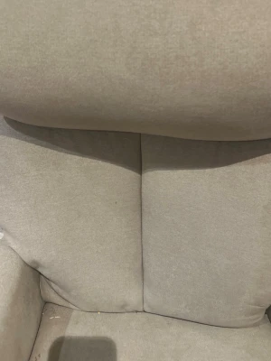 Beige fåtölj med hög rygg - Bekväm fåtölj i beige tyg med hög rygg och breda armstöd. Sitsen är mjukt stoppad och designen är enkel men modern, perfekt för att chilla i vardagsrummet eller plugghörnan. Materialet är textil och färgen är neutral vilket gör att den passar in i de flesta rum.