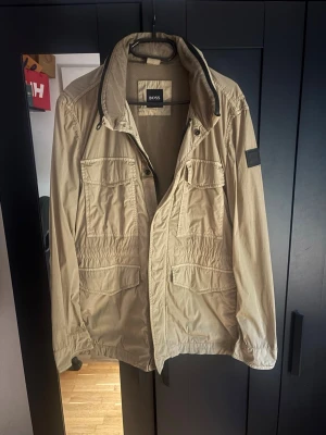 Boss field jacka  - Säljer denna riktigt snygga och stilrena field jacket från boss! Jackan är i utmärkt skick med inga tecken på slitage eller några defekter! Skick: 9/10, en perfekt jacka nu inför sommarkvällar eller även inför hösten!!! Slå gärna en pling ifall man undrar något 🙌