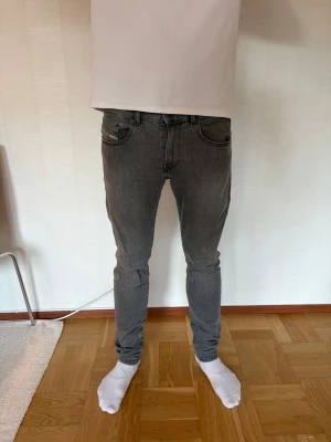 Gråa skinny jeans från Diesel - Säljer ett par gråa skinny jeans från Diesel med klassisk femficksdesign och svarta sömmar. Jeansen har låg midja och smal passform som sitter tight hela vägen ner. Perfekta för dig som gillar en modern och stilren look. Vid frågor hör av dig mvh Ville