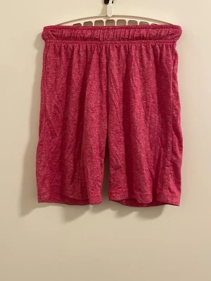 Rosa loose shorts med resårmidja - Säljer ett par sköna rosa shorts med loose passform och resår i midjan. Perfekta för sommardagar eller chill Rosa loose shorts med resårmidja. Materialet känns mjukt och lätt, troligen bomulls eller polyesterblandning. Inga synliga fickor eller detaljer.