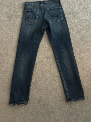 Mörkblå raka jeans - Snygga mörkblå jeans med raka ben och klassisk femficksdesign. Jeansen har en lätt tvättad look med slitningar vid knäna och bakfickor med diskreta sömmar. Perfekta för en avslappnad stil och passar till det mesta. Passar 170 slim fit