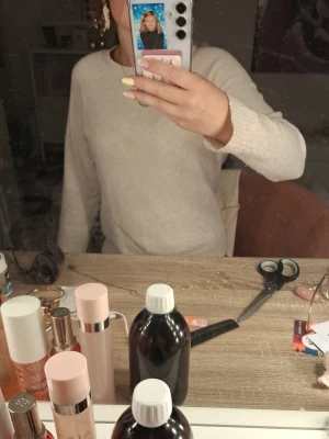 Beige stickad tröja med rund hals - Mysig beige stickad tröja med rund hals och långa ärmar. Tröjan har en enkel och stilren design som passar till det mesta. Perfekt för lager på lager och ger en avslappnad look.