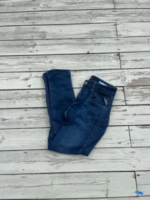 Replay jeans - Snygga mörkblå slim fit jeans från replay med klassisk femficksdesign och kontrastsömmar. Jeansen har dragkedja och knapp i midjan samt diskret logga på fickan. Perfekta för en trendig och avslappnad stil.