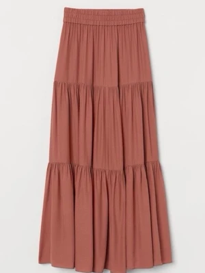 Rostig Brun kjol med smock från H&M - Säljer en rostigbrun kjol från H&M med smock i midjan och mjukt, luftigt tyg. Kjolen har en avslappnad passform och faller snyggt med lätt rynkade detaljer. Perfekt för varma dagar och enkel att styla med accessoarer. Färgen är rostig orange/brun