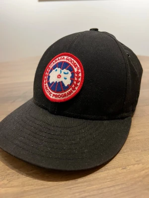 Extremt sällsynt Canada Goose x New era collab - En väldigt sällsynt collab modell mellan Canada Goose och New era. Väldigt lite solblekt. Storleken är L men jag har storlek M i andra kepsar och den passar mig väldigt bra och sitter snyggt! Sitter en gömd ficka på insidan utav kepsen, man öppnar med kardborre där den röda flärpen är i framkant så är hela den främre delen är dold ficka. Tycker du priset är för högt så kom med bud. 