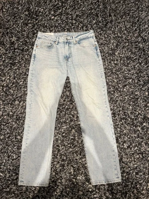 Ljusblå raka jeans i klassisk modell - Säljer ett par ljusblå jeans med rak passform och klassisk femficksdesign. Jeansen är tillverkade i ett mjukt denimtyg. Perfekta för en avslappnad och trendig look.