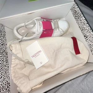 Valentino Garavani Open sneakers vit/rosa - Säljer ett par Valentino Garavani Open sneakers i rosa/vit💓 Äkta!! Dom är lite slitna där bak i hälarna, så säljer dom billigare. Annars är dom i bra skick