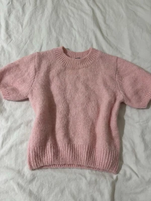 Rosa stickad tröja från Gina Tricot - Supersöt ljusrosa stickad tröja från Gina Tricot med trekvarts ärmar och rund halsringning. Tröjan har ribbstickade muddar vid hals, ärmslut och nederkant. Perfekt för lager-på-lager och en mysig look. Aldrig använd!🌸🫶🏼