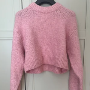 Rosa croppad stickad tröja från H&M - Säljer en supermjuk och mysig rosa stickad tröja från H&M. Tröjan är inte speciellt lång och därför är den väldigt fin till sommaren plus att färgen är ett måste! Nypris är 349kr. Storlek xxs-xs. Skicket är mycket bra och säljer även på Vinted.