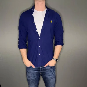 Ralph lauren skjorta - Hej säljer nu min fina Ralph Lauren skjorta i storlek M. Den är i nyskick och kommer vara otroligt snygg nu i vinter och framåt våren. Nypris cirka 1500kr! Vi kommer att sälja liknande produkter nu närmare våren så glöm inte följa profilen!🌊🍾