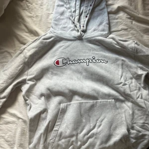 Grå hoodie från Champion - Säljer denna ljusgråa Champion hoodie då den inte används längre. Skulle säga att den passar som storlek S/M beroende på hur lång man är💕 skriv ifall du vill ha flera bilder