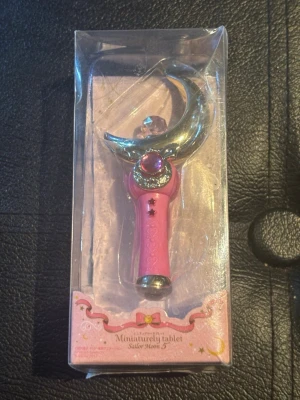 Sailor Moon månstav cosplay-accessoar - Cool månstav från Sailor Moon, perfekt till cosplay eller maskerad. Staven är rosa med silverfärgad måne och dekorativ kristall på toppen. Kommer i originalförpackning och har detaljer i guld och rött.