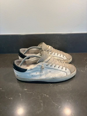 Golden goose skor - Tja säljer nu mina golden goose superstars i storlek 43. Dem är fortfarande i mycket fint skick med endast lite slitage på hälen som ni ser på bilden. Kvitto finns! Hör av er vid frågor eller funderingar:)
