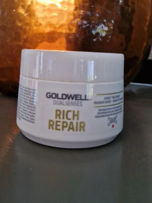 Goldwell Rich Repair hårinpackning - En hårinpackning från Goldwell Dualsenses Rich Repair i en vit rund plastburk med gul text. Perfekt för dig som vill ge ditt hår extra näring och återuppbyggnad. Passar särskilt för torrt eller skadat hår.