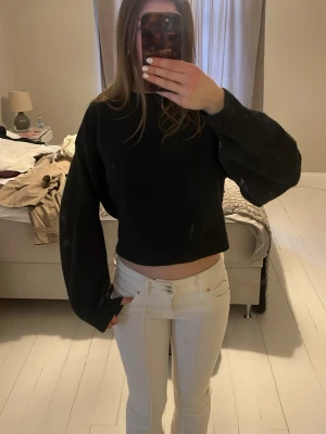 Väldigt mörk grå stickad tröja från weekday  - En nästan svart  stickad tröja från weekday med  ballongärmar. Tröjan har rund halsringning och är tillverkad i mjukt material som ger en skön känsla. Perfekt för att skapa en trendig look.