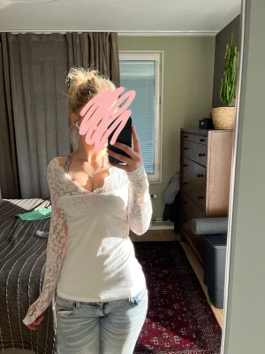 Vit spetstopp med långärmar - Säljer en vit topp med vackra spetsdetaljer och långärmar. Blusen har en feminin v-ringning och är figurnära med transparenta spetsärmar. Perfekt för dig som gillar romantiska och stilrena toppar. Den är skit snygg men den kommer inte helt till användning, har endast testat den men inte användt men tycker dock att den är skit snygg❤️