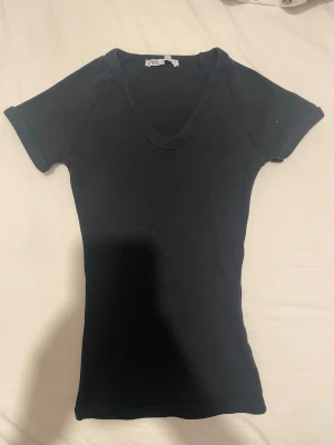 Svart v-ringad topp från Zara - Svart, tight topp från Zara med v-ringning, korta ärmar och ribbad.