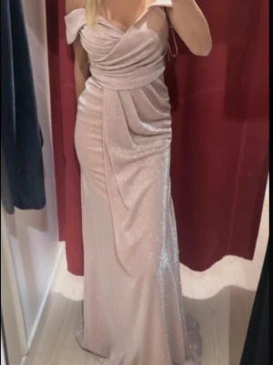 Lång glittrig champagneklänning - Säljer denna glittriga klänning som är handtvättad i storlek XS men passar även s och kan passa M och då den är väldigt stretchig. Endast använt en gång, den har inbyggd bh och köpt i L&S för 2500🤍