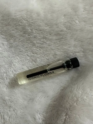 Iconic Flower parfymprov - Litet parfymprov från Iconic Flower i genomskinlig glasflaska med svart skruvkork. Flaskan är cylinderformad och enkel att ta med i väskan. Doften är blommig och modern, perfekt för dig som gillar fräscha toner.