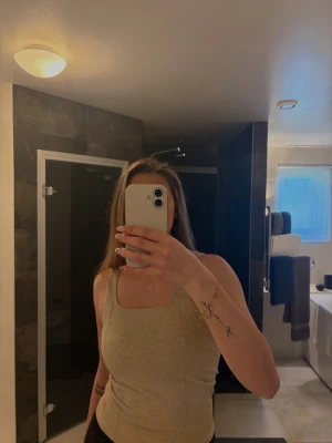 Beige ribbad linnetopp - Säljer en beige ribbad linnetopp med breda axelband och fyrkantig halsringning. Träningstopp med mjukt och stretchigt material, inte använd, endast testad.🤍