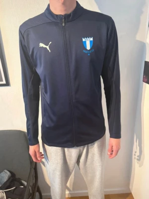 Mörkblå Malmö FF tröja  - Säljer en mörkblå långärmad Malmö FF tröja  Tröjan har mönster  Tröjan har använts ca 4-5 gånger  Tröjans storlek är M (medium)  Det fins inga synliga skador eller tecken av användning  Nytt pris: 800 Kr Vårt pris: 600 Kr  Priser går att diskuteras✨ Tveka inte på att skriva!✅ 