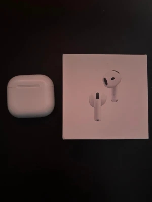 Apple AirPods 4 med laddningsetui - Säljer ett par vita Apple AirPods 4 med trådlöst laddningsetui. Snygg och stilren design i blank plast, perfekt för dig som vill ha smidiga och trådlösa hörlurar till mobilen. Originalförpackning medföljer.