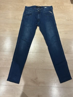 Replay anbass Jeans | W30 - Säljer mina mörkblå Replay Anbass jeans. De är i väldigt fint skick och har en klassisk passform som passar till allt.  Storlek: W30 / L32 Skick: 9/10 (Väldigt fint skick) Färg: Mörkblå  Fraktar så snabbt som möjligt! Skriv om du har frågor eller vill ha fler bilder. 