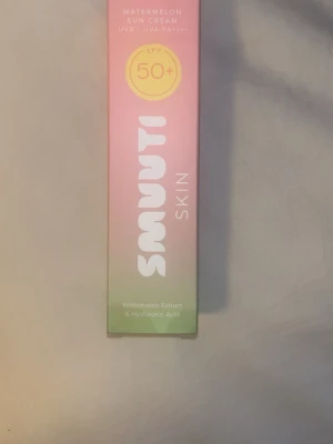 Smuuti Skin Watermelon Sun Cream SPF 50+ - Säljer en Smuutti Skin Watermelon Sun Cream SPF 50+ med extrakt av vattenmelon och hyaluronsyra. Solkrämen kommer i en snygg rosa och grön förpackning och ger högt skydd mot UVA och UVB. Perfekt för dig som vill ha återfuktande solskydd till ansiktet.