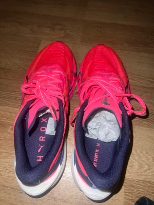 Neonrosa skor från Puma - Snygga neonrosa skor  från Puma med mörkblå detaljer och HYROX tryck för dig som gillar att jogga.  Har haft på mig skorna 3 dagar under event väldigt varsamt, som nya! Säljer eftersom jag fick fel storlek (har storlek 37 och skorna är 38.5) 