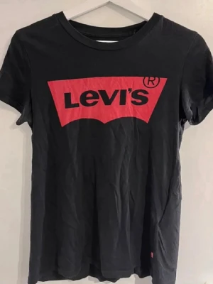  Levi's t-shirt - Klassisk svart t-shirt från Levi's med den ikoniska röda loggan tryckt framtill. 