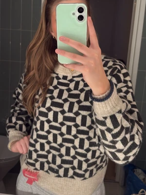 Beige och mörk grön stickad unik tröja - Stickad tröja från ONLY i beige och svart/mörk grönt med grafiskt mönster. Tröjan har rund halsringning och ribbade muddar vid hals, ärmslut och nederkant. Perfekt för dig som gillar en unik och trendig look.