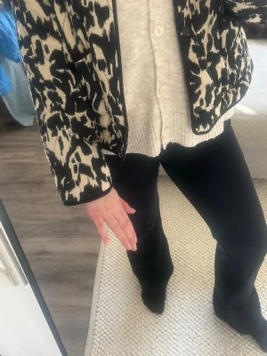 Zara svartvit quiltad jacka - Cool svartvit quiltad jacka från Zara med trendigt abstrakt mönster. Jackan är kraglös, har rund halsringning! Perfekt vårjacka☀️