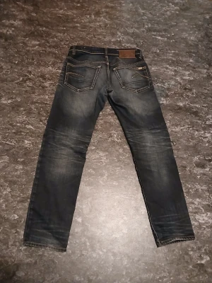 Mörkblå jeans från G-Star - Snygga mörkblå jeans från G-Star med klassisk femficksdesign och coola slitningar på benen. Jeansen är gjorda i rå denim och har kontrastsömmar samt en läderpatch bak. Perfekta för dig som gillar en modern och avslappnad look.