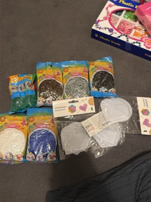 Stort set med Hama pärlor och pärlplattor - Säljer ett stort set med Hama plastpärlor i flera färger som vitt, blått, grönt, brunt, grått och svart samt flera pärlplattor i olika former. Perfekt för kreativa pysselprojekt och att skapa egna mönster och figurer.