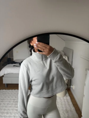 Ljusgrå fleece från Aim'n med halvzip - Supermjuk ljusgrå fleece från Aim'n med halv dragkedja och hög krage. Materialet är fluffigt och värmande, med liten Aim'n-logga framtill. Använd några gånger men ser helt ny ut!