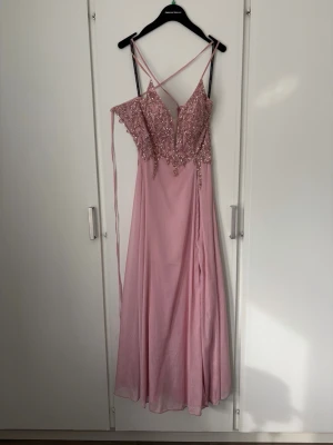 Balklänning - Fin glittrig balklänning, använd vid ett tillfälle. Mycket fint skick. Passar mig som är 168cm lång + 6cm klack. Nypris 7000kr. Fodral att hänga klänningen i finns. 