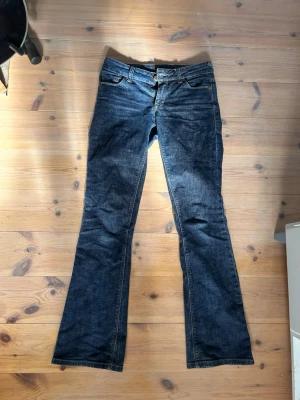 Mörkblå bootcut jeans - Snygga mörkblå bootcut jeans med cool design på fickorna. Låga i midjan och passar till allting! Står stl 27 på lappen men passar som en S, innerbana mått på 80cm💕Vintage ginajeans!! 