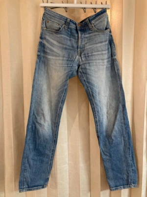 Ljusblå raka jeans med slitningar - Ljusblå jeans med raka ben och klassisk femficksdesign. Snygga slitningar och tvättad look – perfekt för en avslappnad outfit.  • Rak passform • Denim i bomull • Lätt att matcha  Clean, trendig och tidlös.