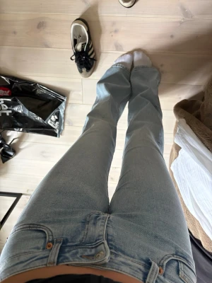 Ljusblå raka jeans med hög midja - Säljer ett par ljusblå jeans med rak passform och låg midja. Jeansen har klassisk femficksdesign och stängs med knapp och dragkedja. Perfekta för en avslappnad och trendig look.