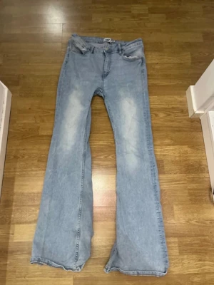 Ljusblå flare jeans från 157 - Säljer ett par ljusblå flare jeans från 157, modellen Snake Flare. Jeansen har utsvängda ben, klassisk femficksdesign och slitningar på låren för en cool vintagekänsla. Perfekta för dig som gillar retrostil och vill sticka ut.