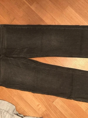 Svarta raka jeans  - Säljer ett par svarta jeans från STR med klassisk femficksdesign och raka ben. Jeansen har en diskret tvättad look och är tillverkade i denim. Använda ett fåtal gånger 