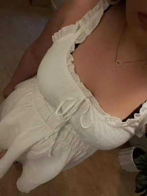 Vit sommarklänning med volangdetaljer - Använd en gång. Tvättad. Superfin klänning. Perfekt till studenten/skolavslutning eller midsommar. Den är väldigt stretchig i midjan. Man får en väldigt fin figur i klänningen🥰