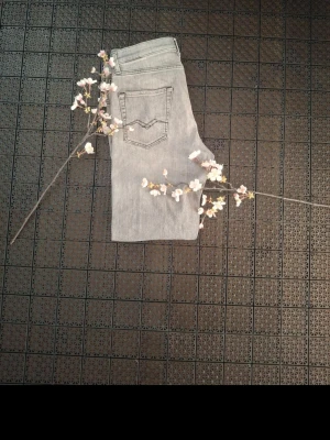 Grå raka jeans med bakficka Replay  - Snygga grå jeans med raka ben och klassisk femficksdesign FrånReplay. Jeansen har en bakficka med dekorativ söm och är tillverkade i ett mjukt denimtyg. Perfekta för en avslappnad och trendig stil.