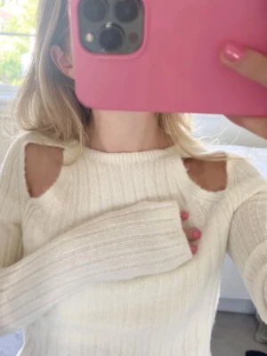 Cool stickad tröja  - Trendig vit stickad tröja med ribbad struktur och unika cut-outs vid axlarna. Storlek M men den passar mig som har Xs. Det beror på hur man vill att den ska sitta💖💖
