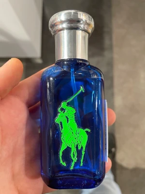 Ralph Lauren Big Pony 1 EdT 50ml - Fräsch parfym från Ralph Lauren ur Big Pony-serien, nummer 1. Flaskan är blå med en stor grön polospelare och har ett silverfärgat lock. Förpackningen är blå med gula och gröna detaljer. Innehåller 50 ml Eau de Toilette spray.