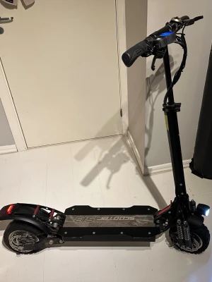 Elsparkcykel 70km/h med tre hasighetslägen (endast upohämtning) - Säljer denna fina och härliga elscootern som jag har haft massa fina sommarminnen av. Har en motoreffekt på 2400 w och åker max 70km/h. Har en räckvidd på 60 km vilket är riktigt härligt. Kan ladda den en gång i veckan om jag kör 2 timmar om dagen! Den har rintigt bra fjädring både bak och fram. Den har tre lägen: 1. åker max 20 km/h 2. 45 km/h 3. 70km/h. Den har även en ”boost knapp” där jag lyckades maxa till 80km/h. Du kan även välja om du vill köra med både bak och framhjul eller endast bak.